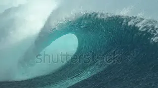 SLOW MOTION, CLOSE UP: Forceful barrel wave splashes beautiful crystal clear water everywhere around