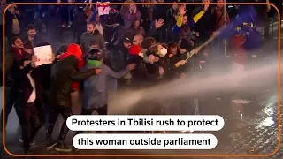 Protesters shield woman outside Georgia parliament