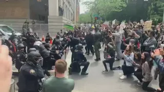 Portland officers kneel with protesters outside Justice Center