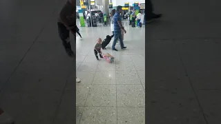 Toddler thinks he's a business man in airport