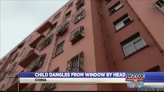 Child dangles from window by head in China