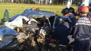 Спасатели извлекают пострадавшего из покореженного авто