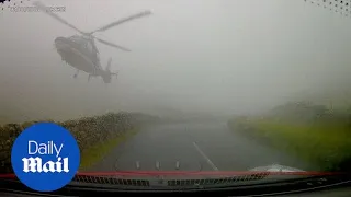 Driver unexpectedly meets low-flying helicopter on misty road