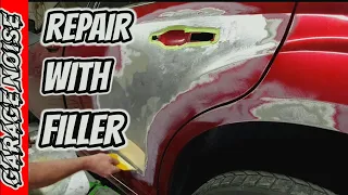 Using body filler to repair a dent in a car. auto body and paint repair