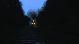 3 steam locos slog uphill through the rainy dawn with a heavy freight