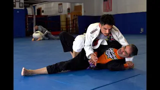 50 year old purple belt rolling with a tough young blue belt