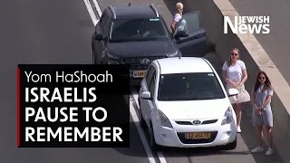 Israelis stop in the streets and step out of cars to mark Holocaust Memorial Day, Yom HaShoah