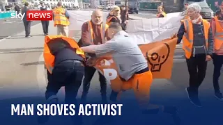 Just Stop Oil: Police handcuff man who shoves protester to ground