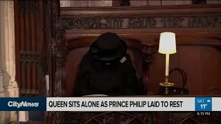 Masked and mourning, Queen sits alone as Prince Philip is laid to rest