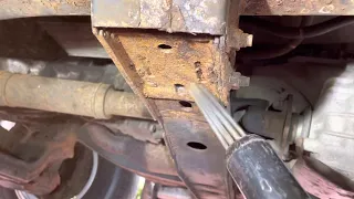 Needle rust remover gun airtool on rusty pickup truck frame