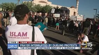 Prayer interrupted by dueling protests