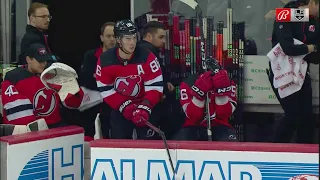 Jack Hughes breaks his stick at the bench and throws it onto the ice.