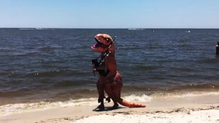 Comtemplative dinosaur playing the Jurassic Park theme on the bagpipes at the beach.