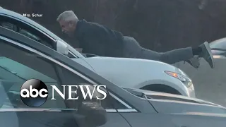 Video shows man hanging from a car hood on the highway