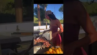 Dua lipa cooking shrimp on a grill that isn’t even on