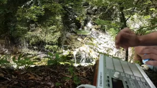 Finger drumming next to a waterfall