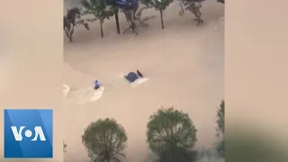 People Swept Down Street by Floodwaters in China