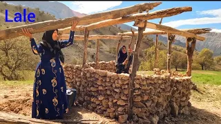 Building a hut in the mountains by two village women with their children