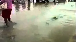 woman makes the huge mistake of walking across a flooded street