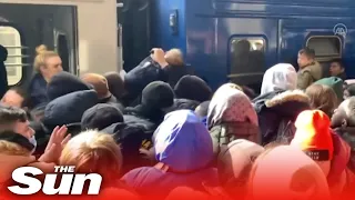 Guns fired as desperate Ukrainians pass child through crowds to board trains out of Kyiv