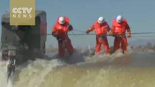 Footage: Firefighters rescue three people trapped in river