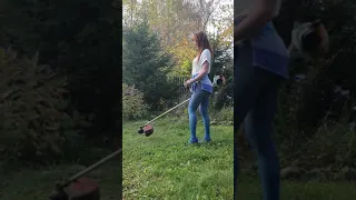 Pretty woman mows the grass