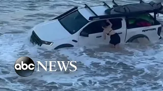 Strong waves sweep pickup truck into dangerous surf as locals attempt to save it