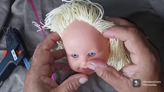 Colocando cabelo de lã em boneca sem cabelo.