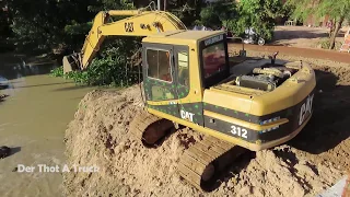 Cat 312 Excavator​ Digging Dredging Mud From the River Canal Near the Red Trail