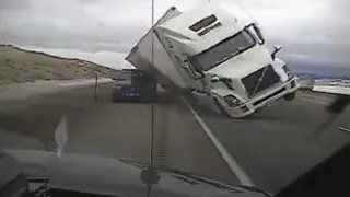 High wind sends tractor-trailer crashing into police car