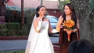 Bride surprises groom singing "Feels like Home" while walking down the aisle