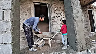 Plastering the columns of the house by a nomadic man and his daughter