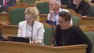 Danish Prime Minister can't hold back laughter after hearing somebody fumigating the chambers.