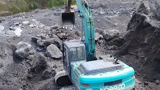 excavator working loading sand into mitsubishi truck in sand mining - 4k