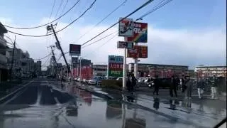 東日本大震災　直後、液状化による泥水と傾く電柱