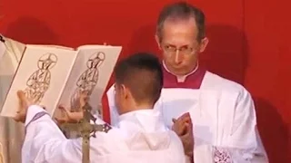 Guido Marini helping an altar boy to hold a Missal