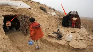 Building a fireplace in the cave before the snow storm by the grandmother and two orphans