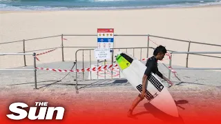 Surfers race onto Bondi Beach as Sydney relaxes lockdown and reopens beaches