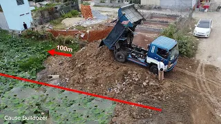 Mitsubishi dozer pushing dirt into the lake with trucks dumping to landfill up make Foundation house