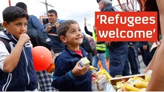 Refugees cheered into Germany and Austria