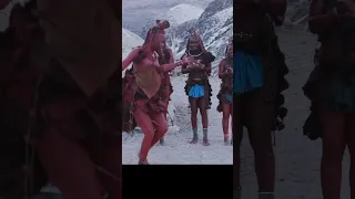4K view of Himba woman in traditional dress dancing and singing outside their clay hut, Namibia