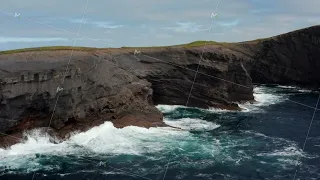 Rising footage of waves crashing on sea coast and making white foam. Splashing on rocky cliffs