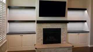 Custom built in cabinets, floating shelves and fireplace mantel
