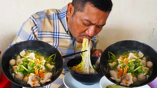 Mouthwatering breakfast, eating delicious pork flat noodle and yellow noodle soup, Cambodian street