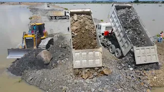 Experience Operator Bulldozer, Dump Truck Work Moving Stone into Water Building Road on Huge Lake