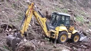 New Holland LB 115.B backhoe digging forest road I.