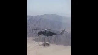 helicóptero carregando um Jeep