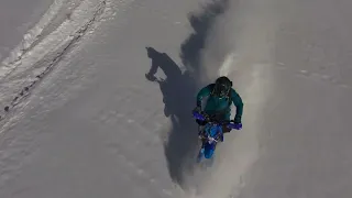 Epic Snow Biking Adventure A Drone's Eye View on a Sunny Day