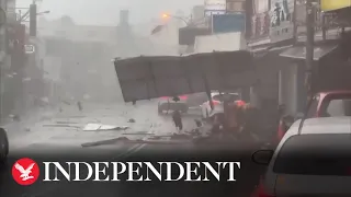 Debris blown down road as Typhoon Koinu brings violent winds to Taiwan