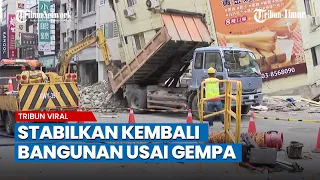 Para pekerja membersihkan puing-puing dan menstabilkan bangunan miring pasca gempa taiwan